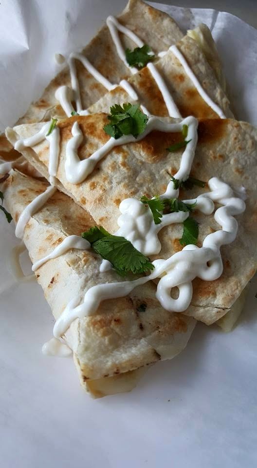 Quesadillas from El Placerito — crispy, topped with crema and cilantro