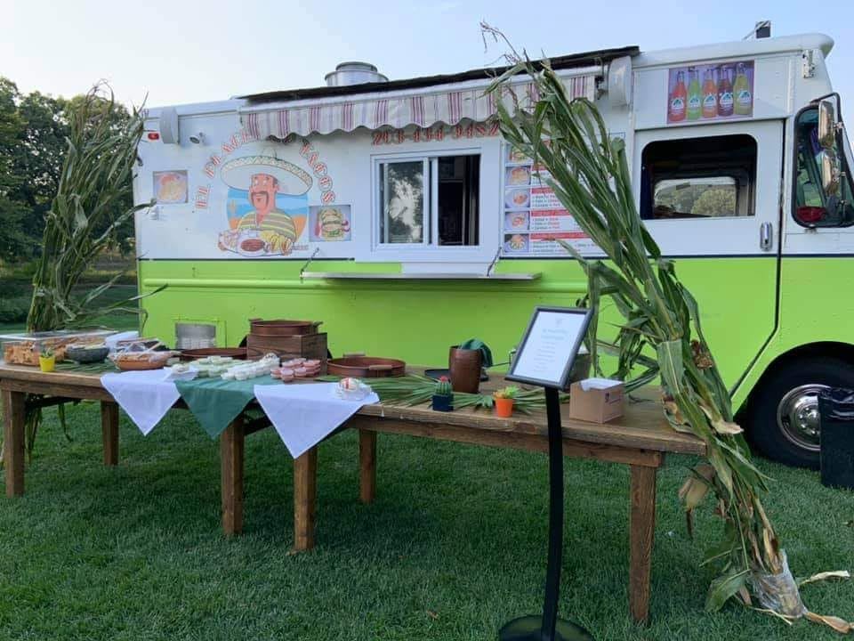 El Placerito Tacos Truck set up for a catering event — rustic tables, outdoor setting, ready to serve